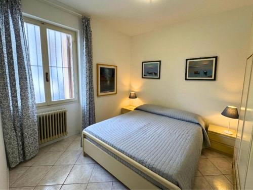 a bedroom with a bed with two lamps and a window at Riviera Appartament in Grado
