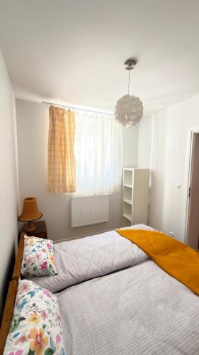 a bedroom with a bed with a yellow blanket on it at APARTAMENT Nowoczesny PRL in Bydgoszcz