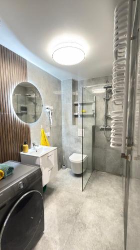 a bathroom with a sink and a toilet and a shower at APARTAMENT Nowoczesny PRL in Bydgoszcz