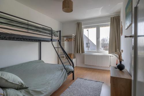 a bedroom with a bunk bed and a window at Warvinge 73 in De Haan