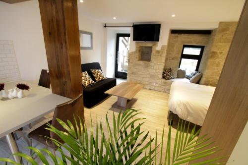 een hotelkamer met een bed en een woonkamer bij Le Moulin d'Oscar & Spa - Mulhouse Nord in Baldersheim