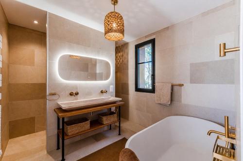 a bathroom with a white tub and a sink at Villa Saint Brice, frontline in Arès