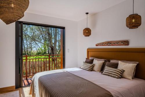 a bedroom with a large bed and a balcony at Villa Saint Brice, frontline in Arès