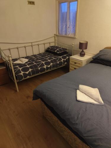 a bedroom with two beds and a lamp and a window at Cristabel Guest House in Clacton-on-Sea