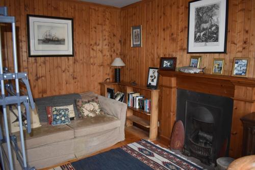 a living room with a couch and a fireplace at The Loan in Achiltibuie