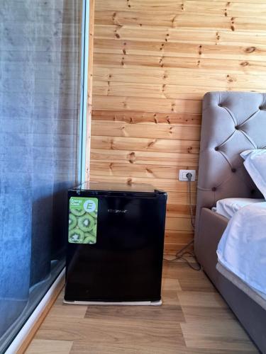 a television in a room with a bed and a couch at Thethi Mountain Villas in Theth