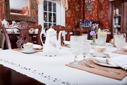 ein Esszimmer mit einem Tisch und einem weißen Tischtuch in der Unterkunft Inn Victoria in Chester