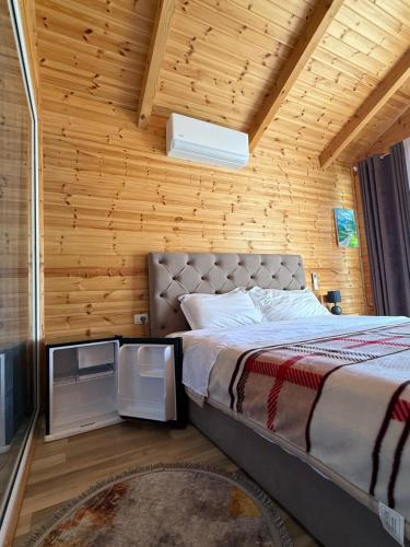 a bed in a room with a wooden wall at Thethi Mountain Villas in Theth