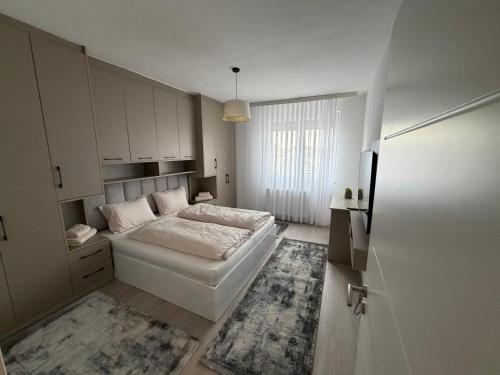 a small bedroom with a bed and a refrigerator at Eda's Home in Mitrovica