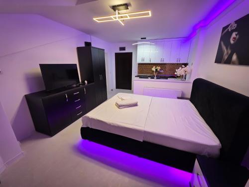 a bedroom with a bed with purple lights on it at Luxury Central Studio in Craiova