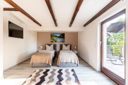 two beds in a room with a window at Haus MALEA by Wohn-Zeit - über 200 Betten im Umkreis von 87700 Memmingen in Fellheim