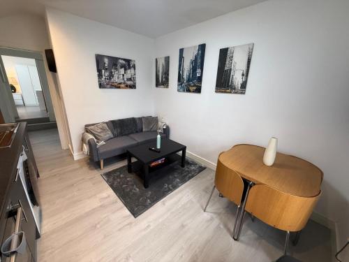 a living room with a couch and a table at Sleek 1BR Flat Perfect Getaway For Contractors Or Couples in Cardiff