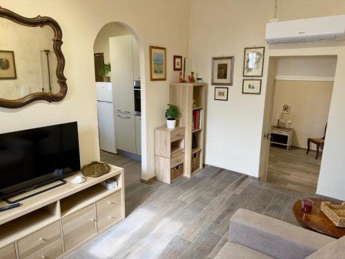 a living room with a flat screen tv and a couch at Casa Falconcini in Volterra