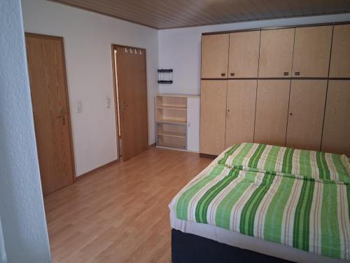 a bedroom with a bed and wooden cabinets at Unterkunft mit Kindernische in Ober-Mörlen