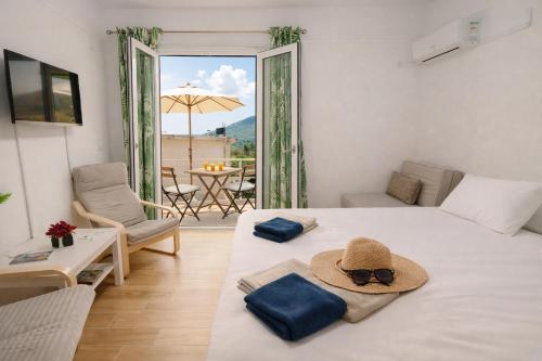 a bedroom with a bed with a hat and a patio at Karavaki apartments in Keri