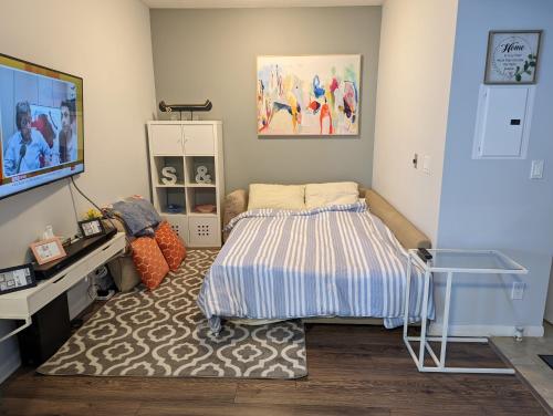 ein kleines Schlafzimmer mit einem Bett und einem Fernseher in der Unterkunft Downtown Condo with Free Parking - SkySide in Toronto