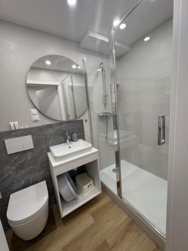 a bathroom with a shower and a toilet and a sink at Dukat Medical Spa in Dąbki