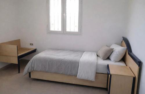 a bedroom with a bed and a desk and a window at Résidence Mestaoui in Houmt Souk