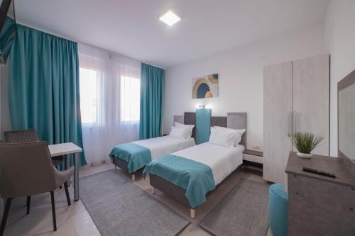 a hotel room with two beds and a desk at AS APARTMANI PIROT in Pirot