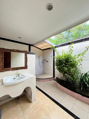 a bathroom with a sink and a large window at Mushroom Beach Bungalows in Nusa Lembongan