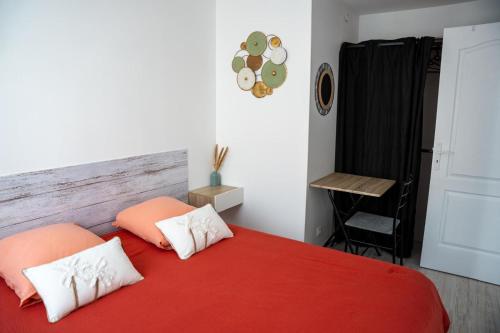 a bedroom with a red bed with two pillows at Maison de ville Libourne 3 chambres in Libourne