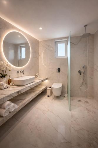 a bathroom with a sink and a toilet and a mirror at Golden Sun in Tigaki