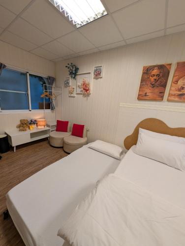 a bedroom with two white beds and a skylight at Travel Light in Tainan