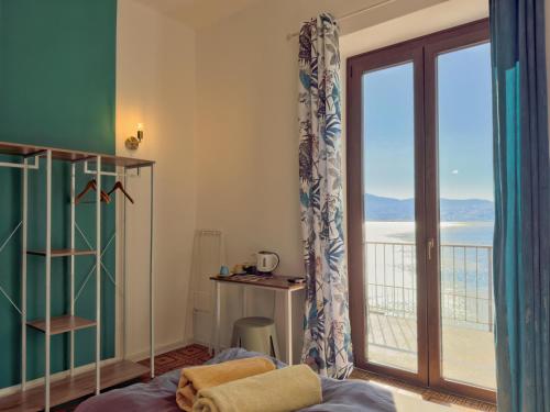 a bedroom with a bed and a view of the ocean at Villa Angelina - Lake View Dreams in Cannero Riviera