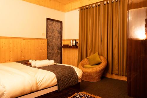 a hotel room with a bed and a chair at The Lume, Lachung in Lachung