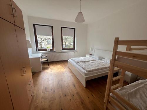 a bedroom with a bed and a desk and two windows at Prázdninový dům Šternberk in Šternberk