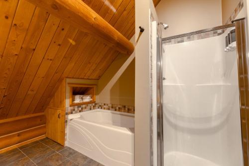 a bathroom with a bath tub and a shower at Overlander Mountain Lodge in Brule Mines