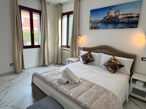 a bedroom with a large white bed and windows at Venice Star Villa in Mestre
