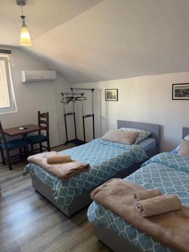 a bedroom with two beds and a table and a table at Hostel FM in Mostar