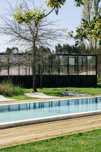 Ein Schwimmbad mit einem Gebäude im Hintergrund in der Unterkunft Rio do Prado in Arelho