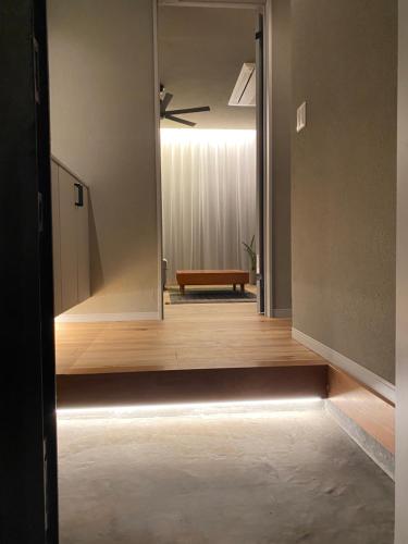 ein Flur mit einem Spiegel und einer Bank in einem Zimmer in der Unterkunft HighLand 伊豆大島箱根連峰を望む高級貸切ヴィラサウナ大型ウッドデッキ薪ストーブ完備 in Arashi