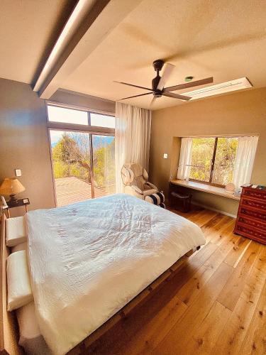 ein Schlafzimmer mit einem großen Bett und einem Fenster in der Unterkunft HighLand 伊豆大島箱根連峰を望む高級貸切ヴィラサウナ大型ウッドデッキ薪ストーブ完備 in Arashi