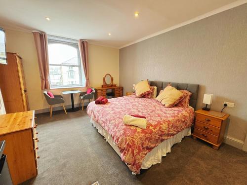 a bedroom with a bed and a desk and a table at White Court Llandudno in Llandudno