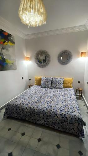 a bedroom with a bed and two mirrors on the wall at La kasbah bleue in Marrakesh