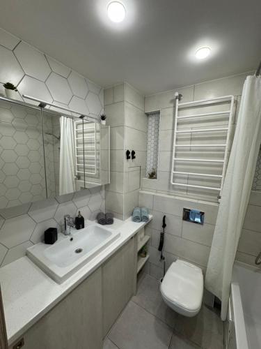 a white bathroom with a sink and a toilet at Apartment near the sea-Sigulda street in Liepāja