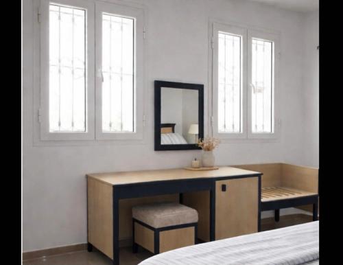 a bedroom with a vanity with a mirror and a chair at Résidence Mestaoui in Houmt Souk