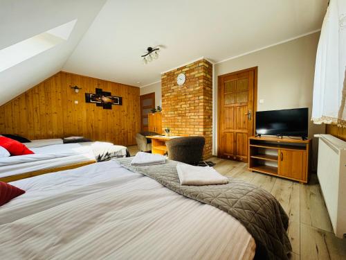 a hotel room with two beds and a flat screen tv at Pokoje U Rycha in Augustów