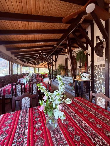 a dining room with red tables and chairs with flowers at Cazare Conacul Tusinean in Petreştii de Jos