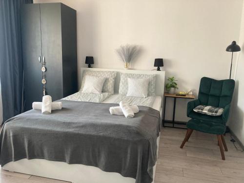 a bedroom with a bed and a green chair at Refugiul Castelului in Hunedoara
