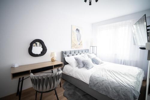 a bedroom with a white bed and a desk at ApartCieszyn - Apartament Liburnia in Cieszyn