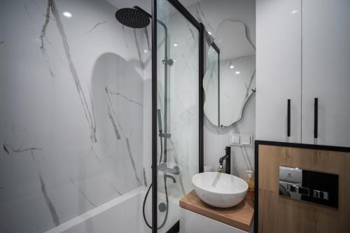 a bathroom with a sink and a glass shower at ApartCieszyn - Apartament Liburnia in Cieszyn