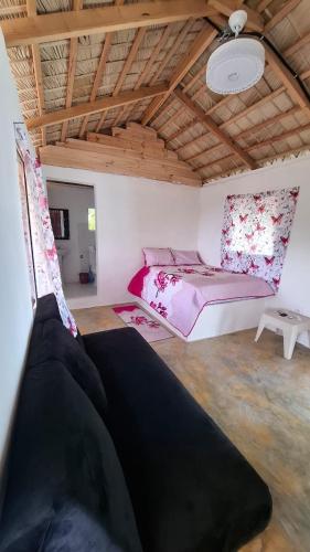 a bedroom with a pink bed and a wooden ceiling at Villa hotel Gabi Larimar in La Ciénaga