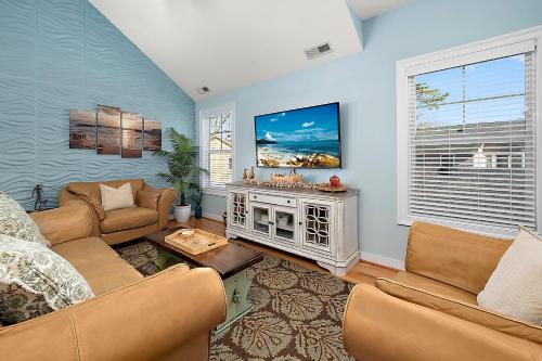 a living room with a couch and a tv at 14111 Fiesta Rd - Cape Canoe in Ocean City