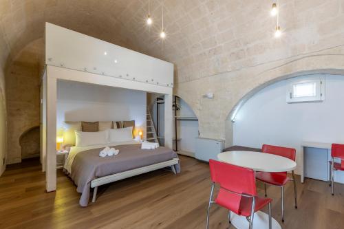 a bedroom with a bed and a table and chairs at Sassolino Dimora Storica in Matera