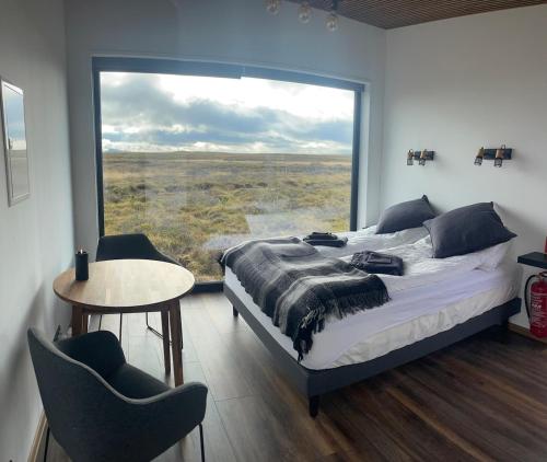 a bedroom with a bed and a large window at Golden Circle Panorama Chalet in Selfoss