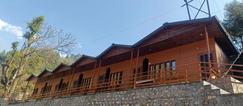 a building on top of a stone wall at trigun pahadi hub in Uttarkāshi